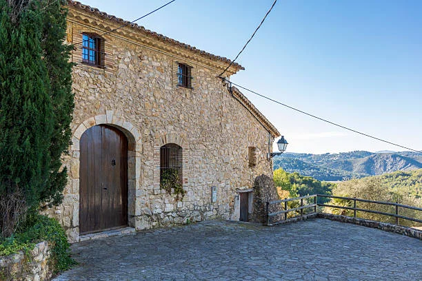 Casa de piedra en el pueblo, con el Garraf al fondo