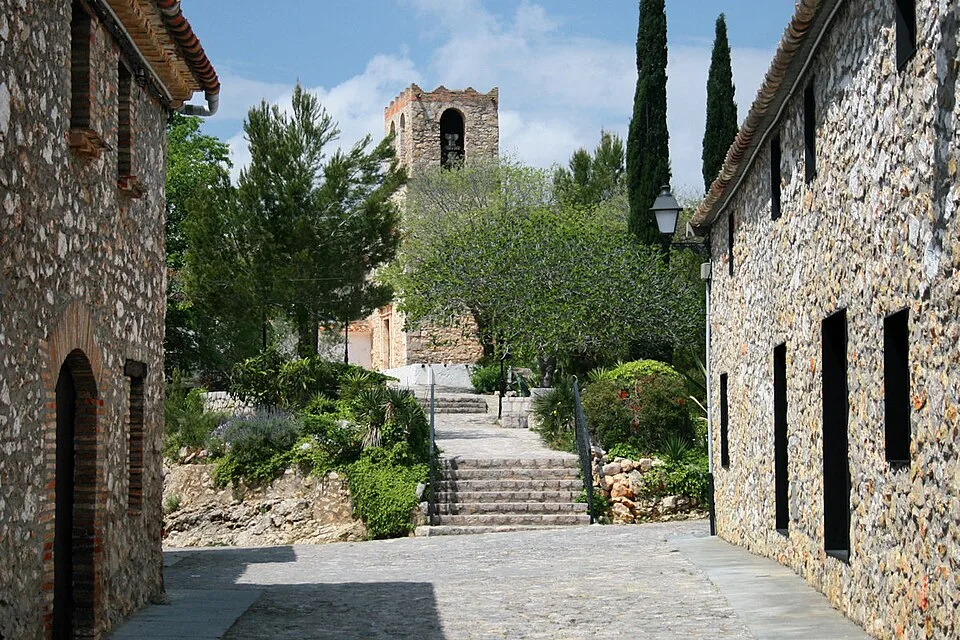 Calle de piedra del pueblo de Olivella con el campanario al fondo